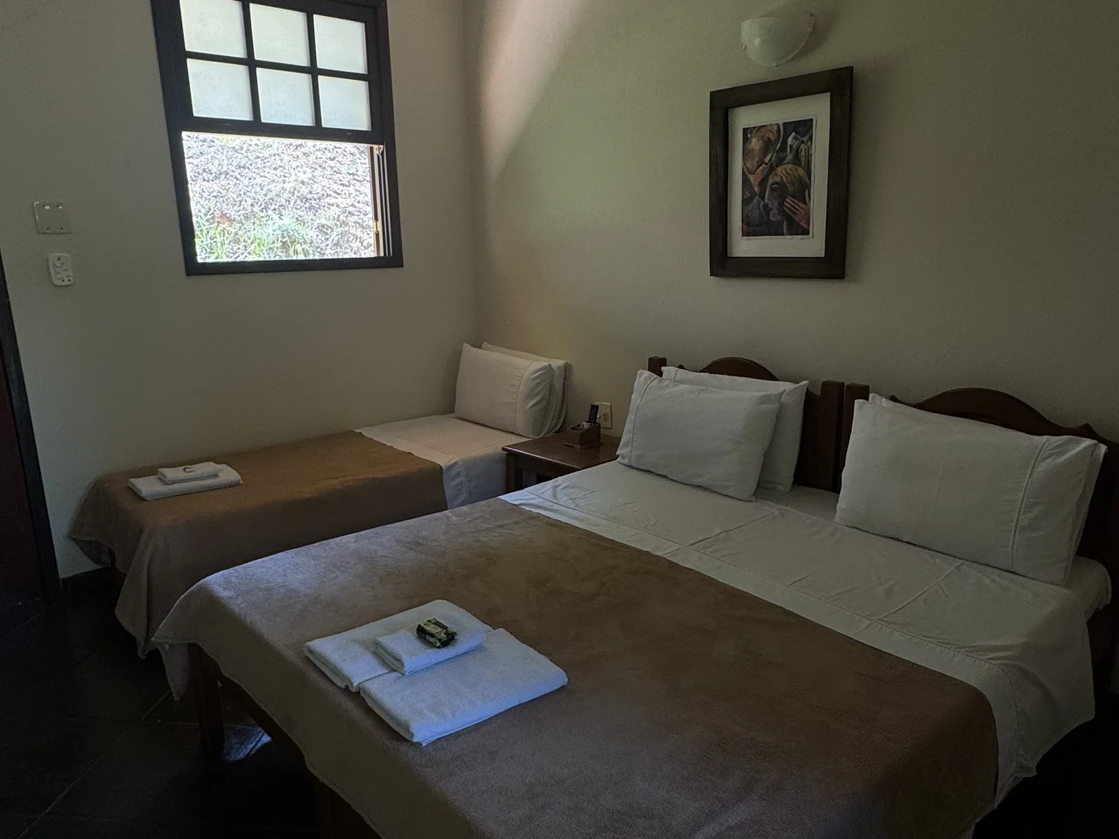 Suíte Varanda com cama de casal e cama de solteiro, vista do quarto inteiro