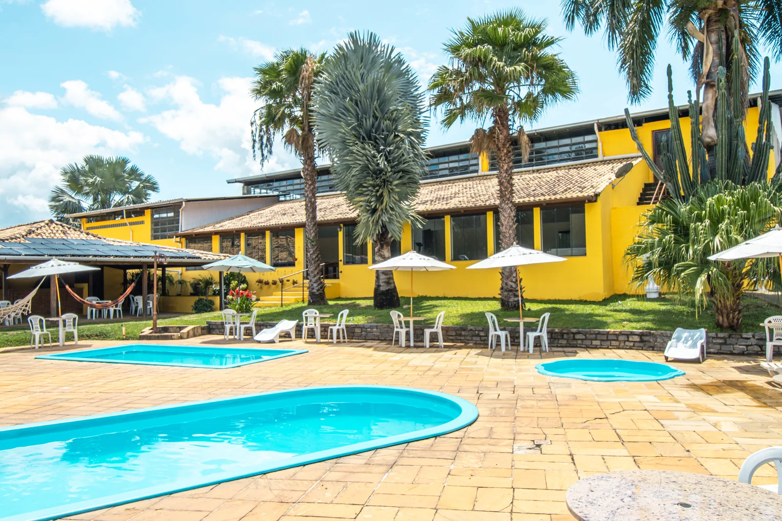 Piscinas externas do Hotel Fazenda Minas Real com espreguiçadeiras e vista para as montanhas