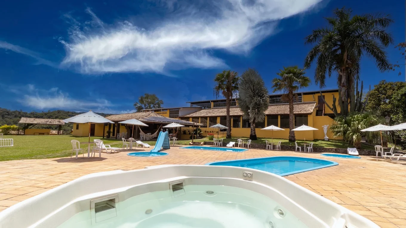 Hidromassagem do Hotel Fazenda Minas Real, com as piscinas e a fachada amarela ao fundo